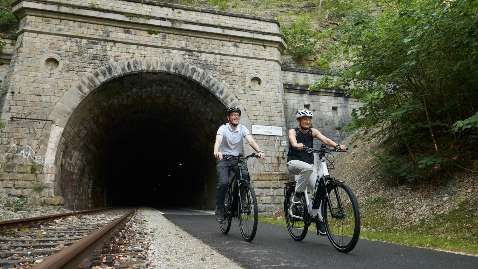 Radfahrer kommen aus einem Tunnel auf dem Kanonenbahnradweg
